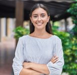 Young beautiful hispanic woman standing with arms crossed gesture at street